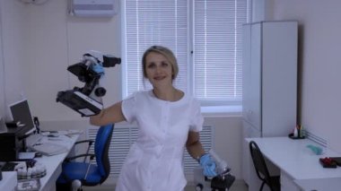 Mutlu kadın laboratuvar teknisyeni elinde mikroskoplar ile laboratuvarda dans.