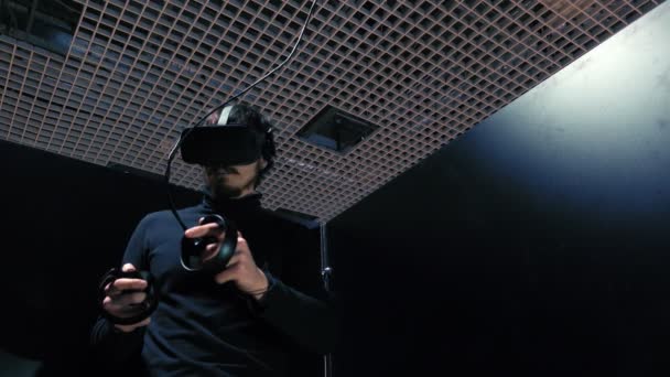 El hombre juega videojuegos en realidad virtual, usando gafas digitales y joysticks . — Vídeos de Stock