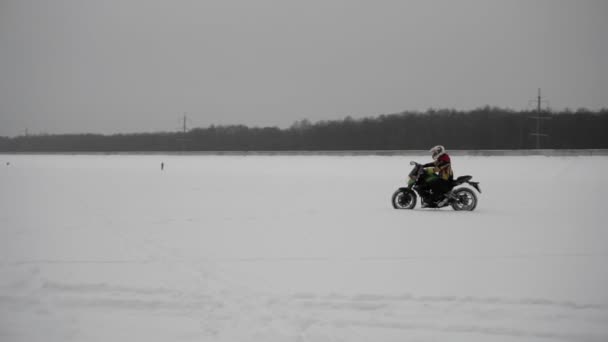 Motorrijder professionele sportman rijdt op Winter baan in de sneeuw, zijaanzicht. — Stockvideo