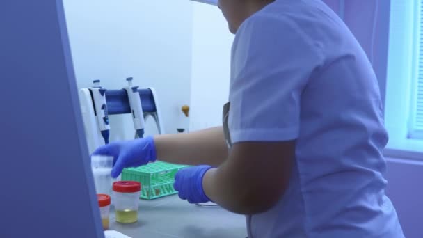 실험실 기술자가 자동 디스펜서 및 테스트 튜브로 작업완료 — 비디오