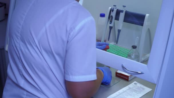 Женщина-лаборант готовит биоматериалы человека к анализу — стоковое видео