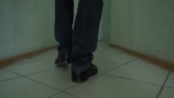 Туфли детектива идут по узкому коридору в поисках необходимой двери — стоковое видео