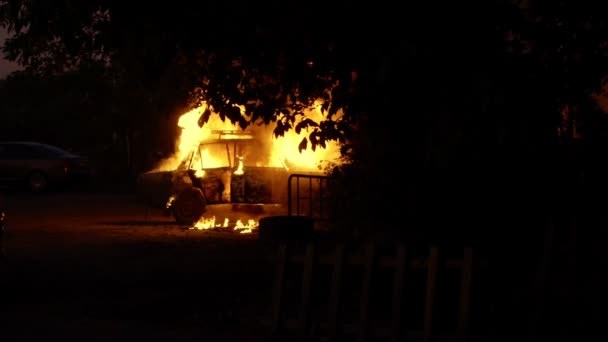 Carro em chamas em uma área residencial da cidade perto de árvores câmera lenta — Vídeo de Stock