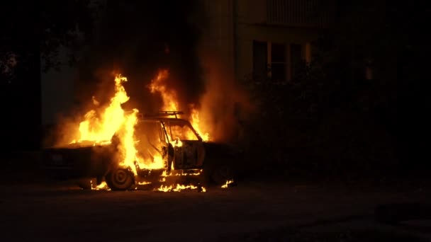 Coche en llamas cerca de una casa en la ciudad de cámara lenta — Vídeos de Stock