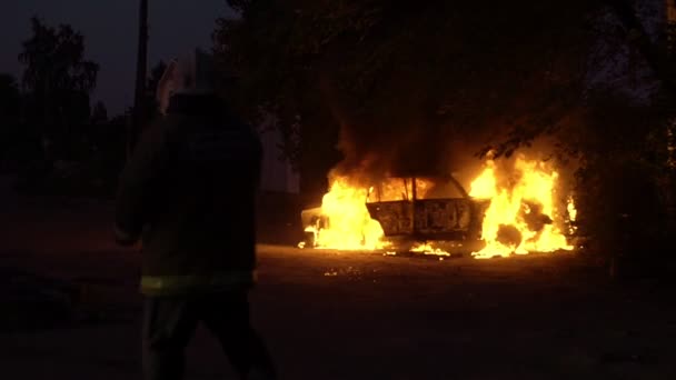 A equipa de bombeiros está a tentar apagar um carro em chamas que explode. — Vídeo de Stock