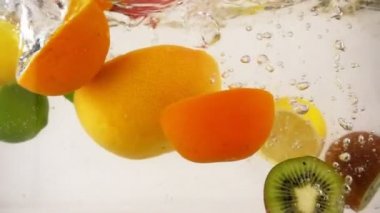 Suya sıçramaları ile düşen meyve farklı yarıları bir kokteyl, multifruit seti, yavaş hareket yakın çekim