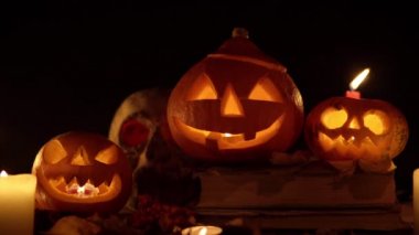 Yanıp sönen ışıkla mum ve masada bir grup balkabağı