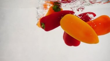 Bir sürü taze çan ve tatlı biber suya dökülüyor. Hem de tam su sıçraması ve kabarcıklarla.