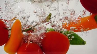 Birçok taze, parlak sebze su ve kabarcıklarıyla suya düşer.
