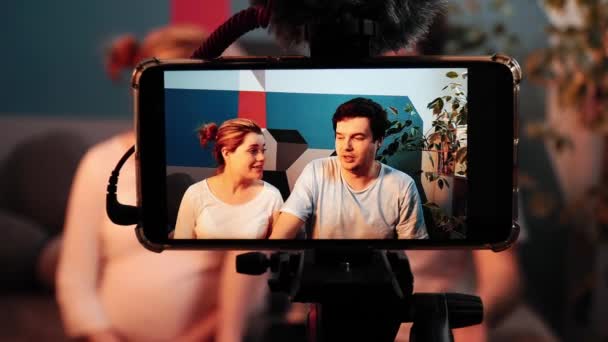 Man and pregnant woman are speaking at the screen of the smartphone — Stock Video