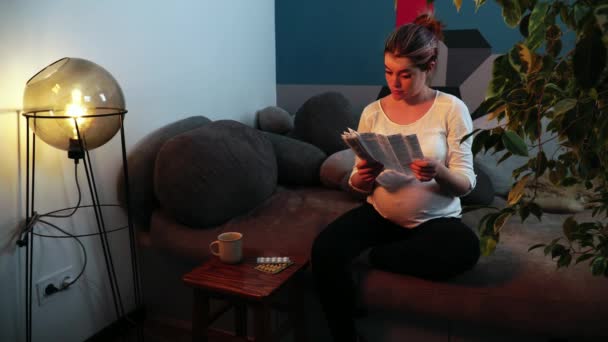 Gravid kvinna läser piller instruktion och kastar blistret — Stockvideo