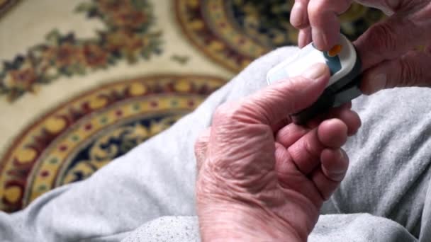 Alter Mann trägt Pulsoximeter und drückt den Knopf — Stockvideo