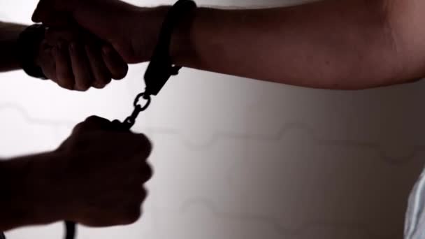 Человек надевает наручники на руку одним профессиональным движением — стоковое видео