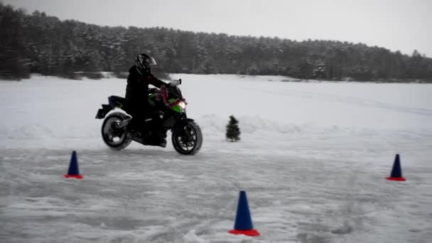 Человек ездит на мотоцикле зимой и делает маневры — стоковое видео