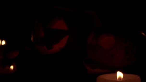 Due lanterne Jack con occhi lampeggianti dal primo piano della fiamma della candela — Video Stock
