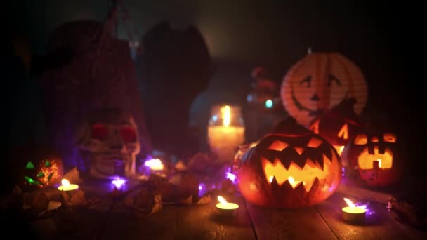 Натюрморт из тыкв, свечей и других атрибутов Хэллоуина за столом — стоковое видео