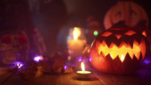 Zucca di Halloween con la luce al suo interno è in piedi al tavolo di legno — Video Stock