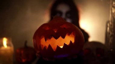 Balkabağı Jack feneri şeytani bir gülümseme ve mumlar kol mesafesinde.