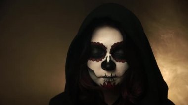 Makyajlı bir kızın portresi Santa Muerte gözlerini sisin arka planına açıyor.