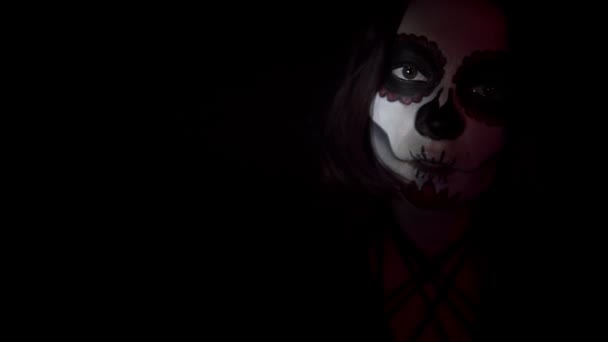 Woman with makeup for the day of the dead smiles enigmatically in the spotlight — Stock Video