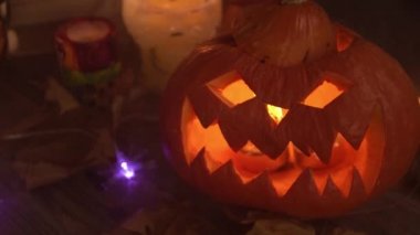 Cadılar Bayramı için oyulmuş balkabağı feneri yakın plan dumanda yanıp sönüyor.