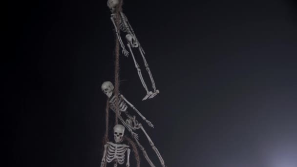 Σκελετοί παιχνιδιών κρεμασμένοι από το λαιμό σε σκούρο φόντο στον καπνό — Αρχείο Βίντεο
