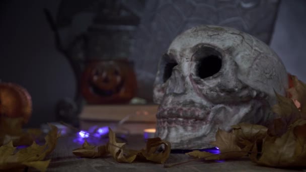 Panning κάμερα από ένα ανθρώπινο κρανίο σε μια διακόσμηση κολοκύθας στο Halloween — Αρχείο Βίντεο