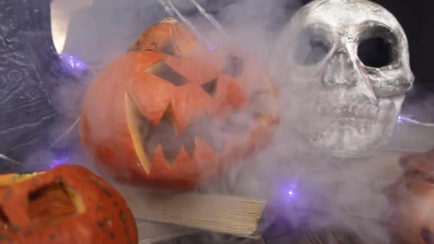Halloween símbolos calabazas y un cráneo en el humo de cerca de cámara lenta — Vídeo de stock