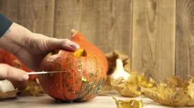 Kız bir balkabağı tutuyor ve keskin bir bıçakla ağzını oyuyor.