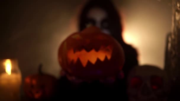 Woman with santa muerte makeup holding pumpkin and moves it forward — Stock Video