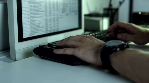 Руки печатают на клавиатуре на столе монитора — стоковое видео