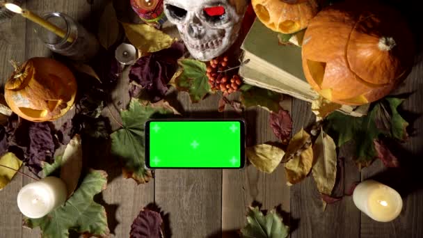 Klepnutím prstem na zelenou obrazovku horizontální telefon na Halloween dekorace — Stock video