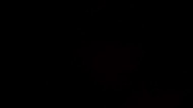 Pembe ışık huzmeleri stüdyonun karanlığında yanıp sönüyor.