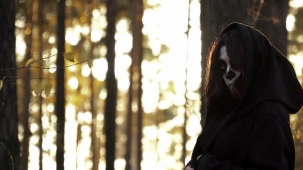 Heks i hætten og santa muerte makeup gå i efteråret skov – Stock-video