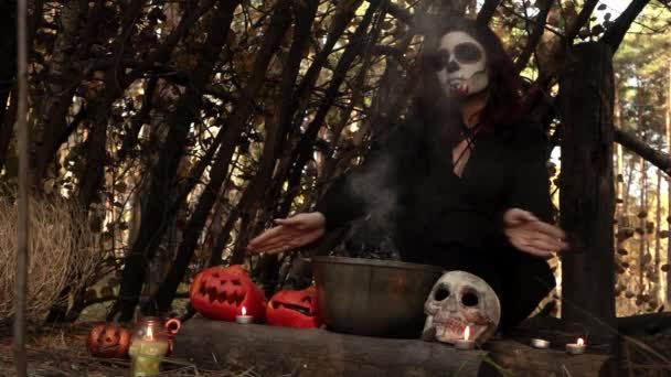 Boszorkány télapó muerte smink mozog kezek felett a vízforraló gőzzel — Stock videók