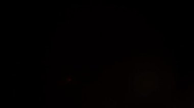 Turuncu ışık noktaları birkaç kez titreşir ve siyah arkaplanda kaybolur