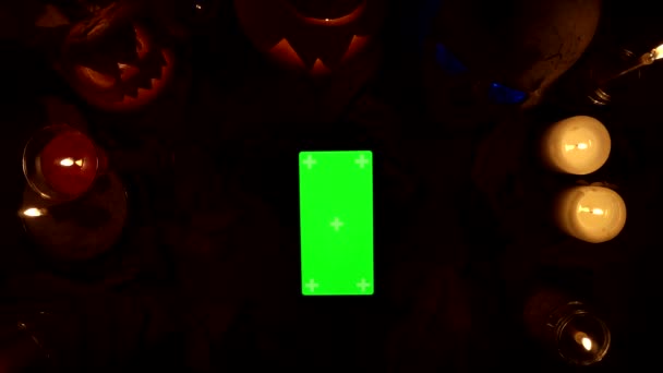 Uso de smartphone vertical con pantalla verde en el fondo de la decoración de Halloween — Vídeo de stock