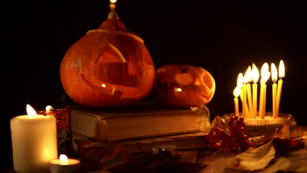 Grupo de Jack-o-linterna de pie en el libro con velas finas ardientes — Vídeo de stock
