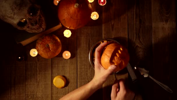 Опорожнение тыквы со страшным лицом для декора в качестве фонаря на Хэллоуин вид сверху — стоковое видео