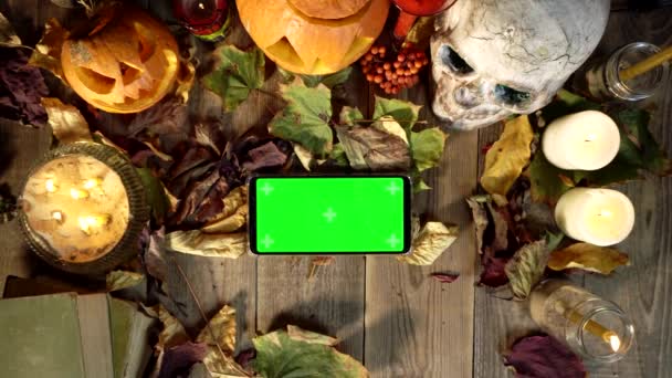 Χειρονομίες της χρήσης ενός smartphone στο παρασκήνιο του Halloween διακοσμήσεις — Αρχείο Βίντεο
