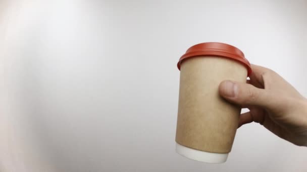 Ο άνθρωπος κρατάει το φλιτζάνι του καφέ στο χέρι του και πίνει από αυτό στο στούντιο. — Αρχείο Βίντεο