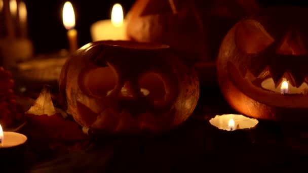 キャンドルや葉をコンセプトにした明るい邪悪な恐ろしいカボチャハロウィンスライダーカメラ — ストック動画