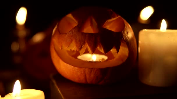 Lächelnder Halloween-Kürbis im Kerzenschein leuchtet nachts als Laterne — Stockvideo