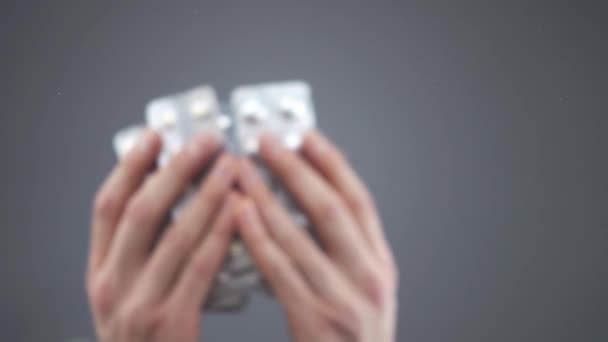 Кавказские руки бросают серебряные волдыри с различными таблетками в замедленной съемке — стоковое видео