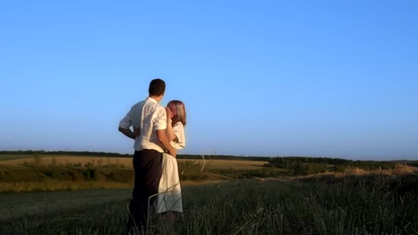 Slowmo de homem e mulher que estão de pé e beijando em um campo de verão — Vídeo de Stock