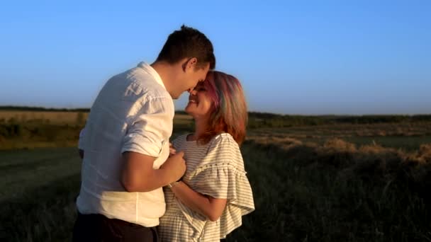 Cámara lenta de la mujer que está sonriendo y susurrando secreto al hombre de pie en el campo de verano — Vídeo de stock