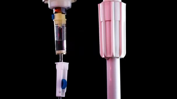 Primer plano de la droga que gotea dentro del gotero intravenoso que cuelga en un estante — Vídeo de stock