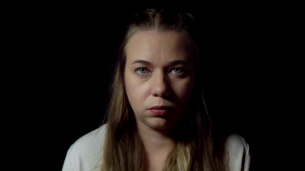 Retrato aislado de una joven seria sobre fondo negro — Vídeos de Stock