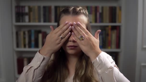 Potret wanita Kaukasia serius yang menutup mata dengan tangan dan membukanya duduk di kamar — Stok Video