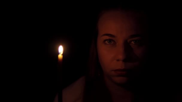 Изолированный портрет на черном фоне женщины, которая выглядит грустной, а затем раздувает свечи улыбаясь — стоковое видео